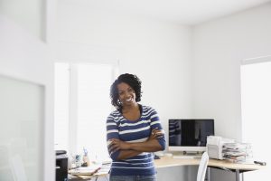Happy woman standing in home office