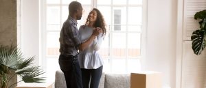 Happy African American couple dancing together in a new home.